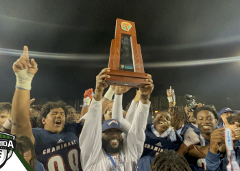 Chaminade-Madonna HC Dameon Jones holds up the Class 1M State Championship trophy after the Lions defeated Clearwater Central Catholic 48-14 on Thu., Dec. 8, 2022 at Gene Cox Stadium in Tallahassee, Fla. [Joshua Wilson/FloridaHSFootball.com]