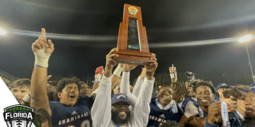 Chaminade-Madonna HC Dameon Jones holds up the Class 1M State Championship trophy after the Lions defeated Clearwater Central Catholic 48-14 on Thu., Dec. 8, 2022 at Gene Cox Stadium in Tallahassee, Fla. [Joshua Wilson/FloridaHSFootball.com]
