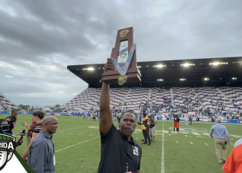 Lake Wales head coach Tavaris Johnson holds up the state championship trophy, the first to be won by the Highlanders' football program on Friday, December 16, 2022 at DRV PNK Stadium in Fort Lauderdale, Fla. [Joshua Wilson/FloridaHSFootball.com}