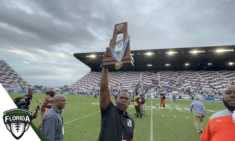 Lake Wales head coach Tavaris Johnson holds up the state championship trophy, the first to be won by the Highlanders' football program on Friday, December 16, 2022 at DRV PNK Stadium in Fort Lauderdale, Fla. [Joshua Wilson/FloridaHSFootball.com}