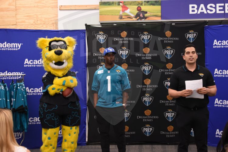 Jacksonville Jaguars RB Travis Etienne Jr. and  axson De Ville look on as Adriel Rocha (right), Jaguars VP of Community Impact and Football Development speaks at the 2024 Jaguars All-PREP Flag Football recognition event held at Academy Sports + Outdoors on Southside Blvd. on Wed. May 8, 2024, in Jacksonville, Fla. [Joshua Wilson/FloridaHSFootball.com]