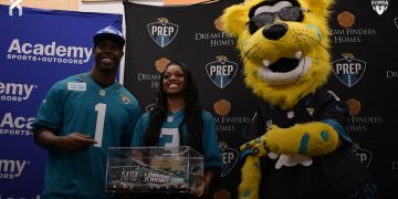 London Jenkins, Fleming Island poses with Travis Etienne Jr and Jaxson De Ville of the Jacksonville Jaguars after receiving the 2024 Player of the Year Award at the 2024 Jaguars All-PREP Flag Football recognition event held at Academy Sports + Outdoors on Southside Blvd. on Wed. May 8, 2024, in Jacksonville, Fla. [Joshua Wilson/FloridaHSFootball.com]